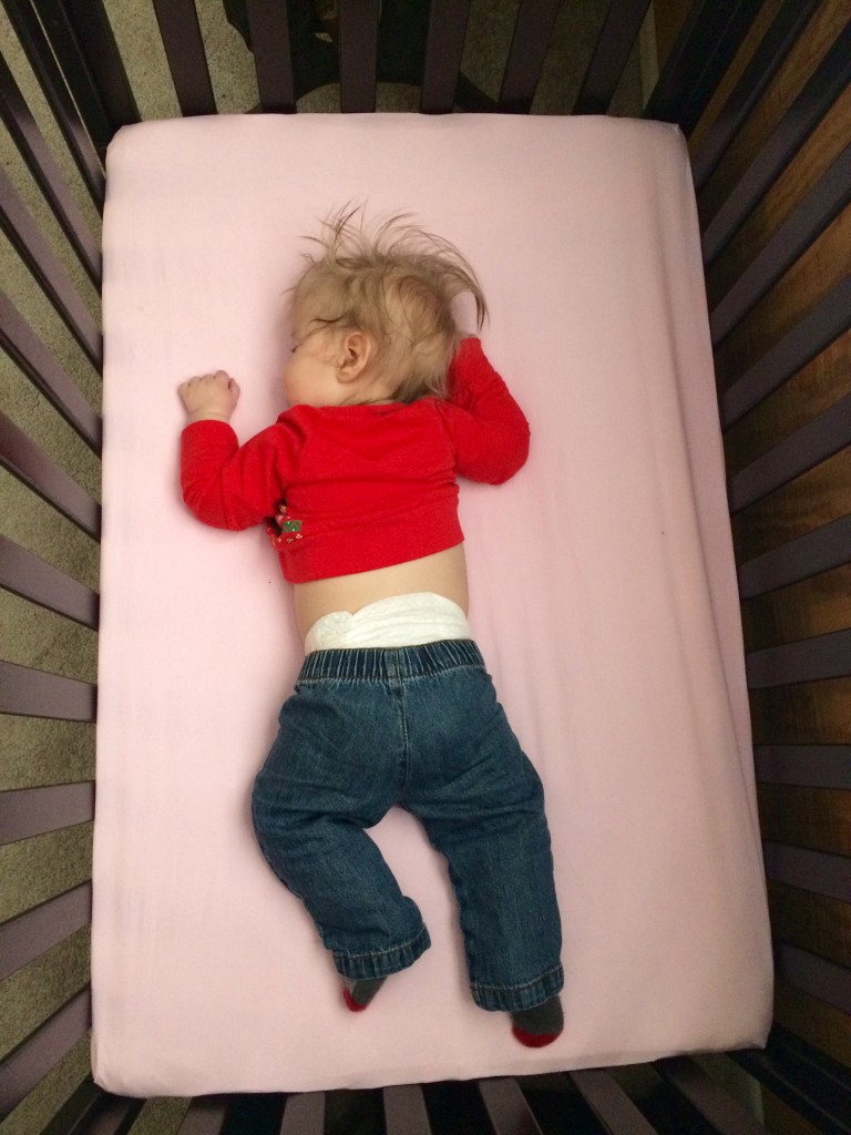 Napping in his crib, wearing tiny jeans, like a big boy. 